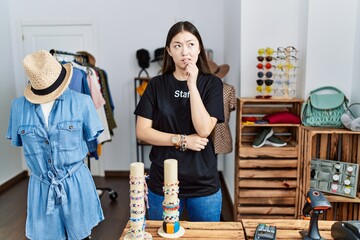 Young asian woman working as manager at retail boutique thinking worried about a question, concerned and nervous with hand on chin