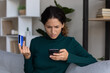 © fizkes - Internet scam. Concerned young hispanic lady looking on smartphone screen having finance savings stolen from bank card as money fraud result. Upset nervous latin woman become online scammers victim
