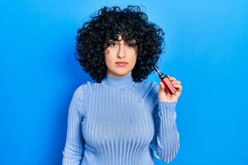 Wall Mural - Young middle east woman holding electronic cigarette thinking attitude and sober expression looking self confident