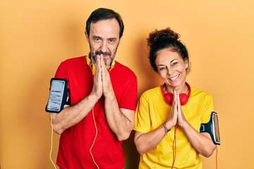 Sticker - Middle age couple of hispanic woman and man wearing sportswear and arm band praying with hands together asking for forgiveness smiling confident.