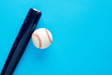 Wall Mural - Wooden baseball bat and a baseball ball on blue background