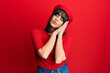 © Krakenimages.com - Young hispanic woman wearing french look with beret sleeping tired dreaming and posing with hands together while smiling with closed eyes.