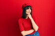 © Krakenimages.com - Young hispanic woman wearing french look with beret with hand on chin thinking about question, pensive expression. smiling with thoughtful face. doubt concept.