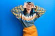 © Krakenimages.com - Young hispanic woman wearing casual winter sweater doing ok gesture like binoculars sticking tongue out, eyes looking through fingers. crazy expression.
