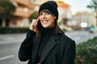 © Krakenimages.com - Young hispanic woman smiling happy talking on the smartphone at the city.