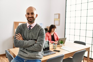 Businessman smiling happy with arms crossed gesture. Employee working at the office