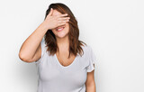 Fototapeta  - Young plus size woman wearing casual white t shirt smiling and laughing with hand on face covering eyes for surprise. blind concept.