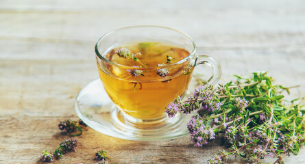 Wall Mural - Thyme tea in a transparent cup. Selective focus.