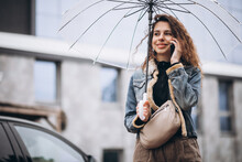 Young Woman Walking In The Rain With Umbrella