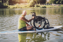 Person With A Physical Disability Ride On Sup Board With His Wheelchair