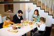 © BGStock72 - Family using mobile phones while having breakfast at dining table at apartment