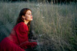 © VICHIZH - woman in the field lies on the grass in a red dress posing