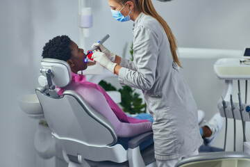 Wall Mural - Woman performing a dental procedure on a patient