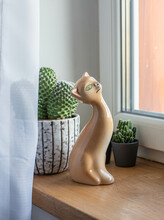 Porcelain Cat Figurine  On The Window Sill With Cactus Plants In Mid-century Modern Pot