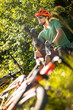 © lightpoet - Young man biking on a mountain bike enjoying healthy active lifestyle outdoors in summer - taking a break, eating a fruit gel (shallow DOF)