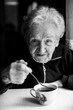 © De Visu - Portrait of a grandmother with a cup of tea. Black and white photo.