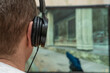 © yaroslav1986 - Close-up rear view of a young man with headphones playing an action video game on a computer at home