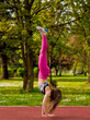 © qunica.com - Young sexy woman doing handstand training after jogging in the park