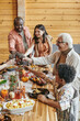 © pressmaster - Cheerful family members toasting with drinks over table served with homemade food prepared for festive dinner