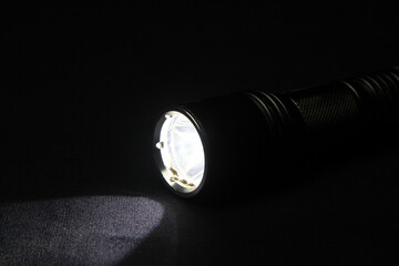 Metallic black flashlight. Handheld pocket torch 