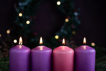 Close-up of four burning purple advent candles.