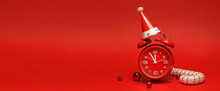 Alarm Clock With Party Hat And Christmas Decorations On Red Background With Space For Text