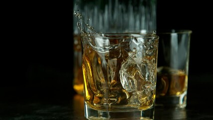 Wall Mural - Super slow motion of falling ice cube into whiskey drink. Camera movement. Filmed on high speed cinema camera.