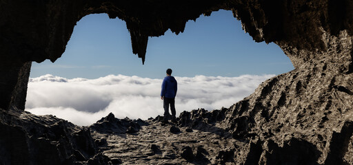 Wall Mural - dramatic adventurous scene with man standing inside an alien like rocky cave landcspae. 3d rendering