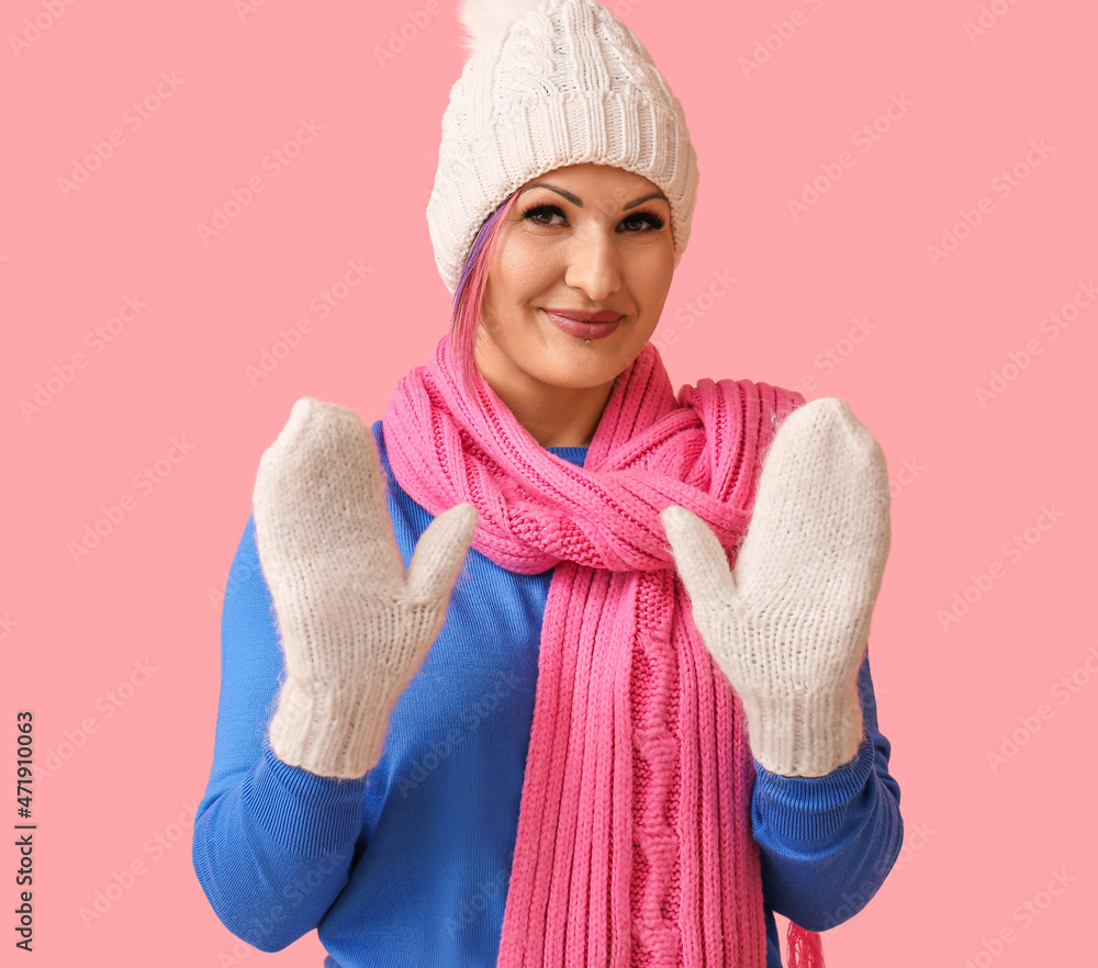 Woman in winter clothes on color background