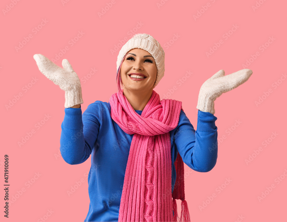 Woman in winter clothes on color background