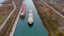 Two Cargo Ships Maneuver Inside The Beauharnois Canal In The St Lawrence Seaway, Near Montreal, Quebec. High Quality 4K Aerial View.