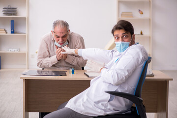 Old male patient visiting young male doctor during pandemic in f