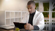 © goodluz - portrait of an African doctor working on his tablet in a meeting room in a hospital