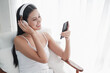 © u photostock - Asia woman sitting on the chair in morning with headphone and smart phone