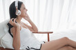 © u photostock - Asia woman sitting on the chair in morning with headphone and smart phone