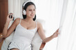 © u photostock - Asia woman sitting on the chair in morning with headphone and smart phone
