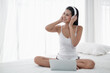 © u photostock - Asia woman sitting on the bed in morning with headphone and laptop