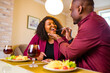 © yurakrasil - african american couple in love drinking wine from glasses and eating italian pasta in living room 14 february valentines day