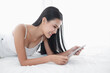 © u photostock - Asia woman lying on the bed in morning with tablet