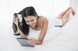 © u photostock - Asia woman lying on the bed in morning with tablet