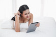© u photostock - Asia woman lying on the bed in morning with tablet