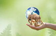 Earth Day or World Wildlife Day concept. Save our planet and animals, protect nature reserve, protection of endangered species, biological diversity. Elephant, tiger, deer, parrot and globe in hand.