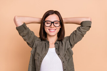 Sticker - Photo of cheerful relaxed lady hands head beaming smile wear khaki shirt isolated beige color background