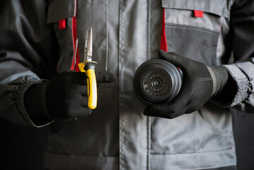 Wall Mural - Video surveillance service worker holds a cctv security camera close up.