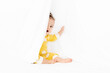 © Lisa Tichané - Cute baby in yellow pajamas peeking behind white sheet