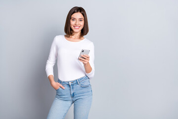 Wall Mural - photo of optimistic bob hairstyle young lady type telephone wear pullover jeans isolated on grey col