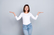 © deagreez - Photo of charming cute young woman wear white outfit comparing arms empty space smiling isolated grey color background
