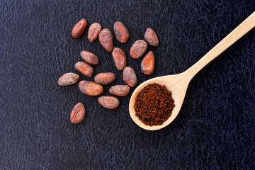 Wall Mural - Cocoa powder and cacao beans on dark table background. Top view. Flat lay.