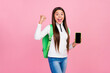 Photo of hooray brunette teen girl yell show telephone wear sweater bag jeans isolated on pink color background