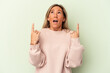 © Asier - Young caucasian woman isolated on green background pointing upside with opened mouth.